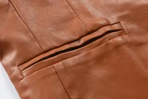 Close-up detail of brown men's PU leather vest showing pocket and fine stitching craftsmanship.