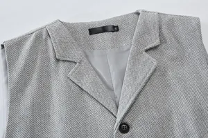 Men's business suit vest detail shot showing herringbone fabric, lapel collar and buttons.