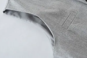 Men's vintage herringbone vest detail close-up, showing premium textured fabric and fine stitching.