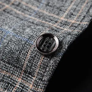 Men's business casual suit jacket close-up, grey plaid blazer fabric detail with stylish button.