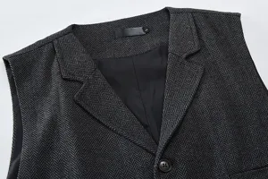 Men's herringbone suit vest detail shot showing lapel collar, black lining and textured fabric.