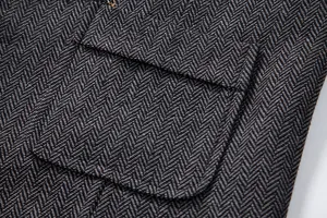 Men's herringbone tweed vest detail shot showing premium fabric texture and pocket flap.
