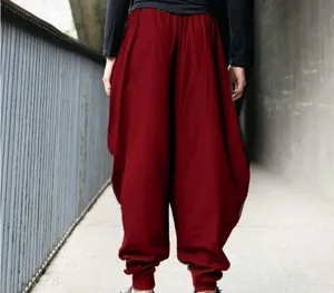 Detailed view of loose wine red harem pants with comfortable dropped crotch and tapered cuffs.