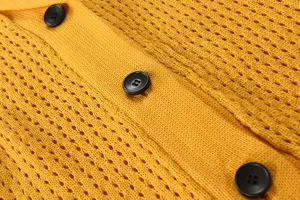 Nahaufnahme eines gelben Strickjacke-Pullovers, strukturierter Strickstoff mit schwarzen Knöpfen.