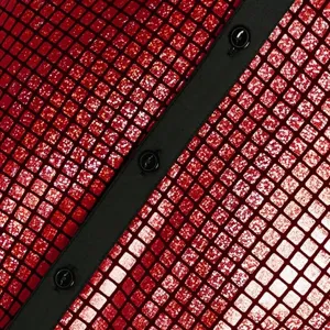 Primer plano de los detalles de la camisa de lentejuelas rojas con botonera negra.