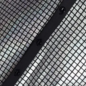 Primer plano de tela de camisa disco con lentejuelas plateadas, tira de botones negros.