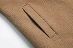 Close-up detail view showing the exquisite pocket craftsmanship and fine camel wool fabric texture.