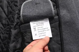 Men's wool coat detail inner lining and washing care label close up professional view