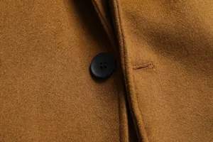 Close-up detail of mens wool trench coat fabric texture and button. Premium winter.
