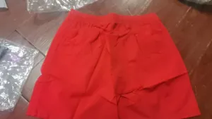 Détail de short de plage décontracté pour homme rouge, design uni taille élastique.