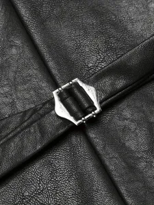 Dettaglio gilet in pelle da uomo con fibbia in metallo e raffinata texture nera effetto pelle.