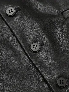 Primo piano dettagliato del gilet in pelle nera da uomo con texture fine, bottoni e cuciture.