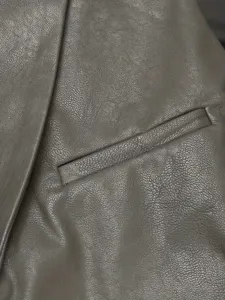 Primo piano dettaglio della tasca del gilet in pelle da uomo e texture del risvolto con cuciture.