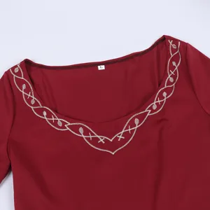 Detailed view of a medieval vintage dress with elegant silver embroidery on a square neckline.