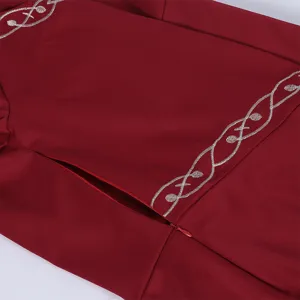Close-up detail of medieval vintage dress, burgundy fabric with elegant silver vine embroidery.