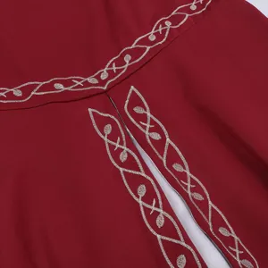 Close-up detail of medieval retro dress featuring exquisite silver vine embroidery on red fabric.