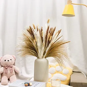 Natural dried pampas grass bouquet with white ceramic vase for home decor and wedding setup.