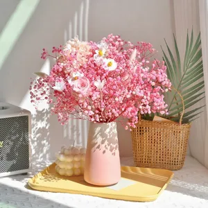 Boeket van gedroogde rozen en gipskruid bloemen met keramische vaas voor interieurdecoratie.
