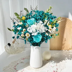 Bouquet de roses stabilisées bleu et blanc avec vase en céramique pour la décoration de la maison.
