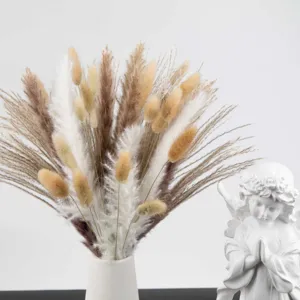Detailed view of mixed dried bunny tails and pampas grass bouquet in a white ceramic vase.