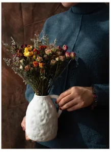 Dried flower bouquet with multi-head roses in a white ceramic vase, retro vintage decor.