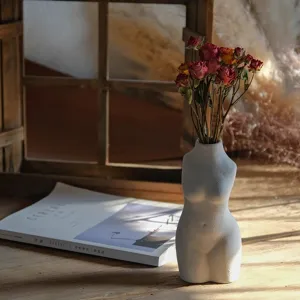 Ceramic female torso flower vase with dried rose bouquet for retro living room home decor.