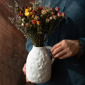 Vintage dried flower bouquet with white ceramic vase for home decor and photography props.