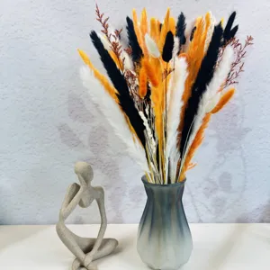 Gros plan de bouquet de fleurs séchées colorées dans un vase élégant avec une jolie déco.