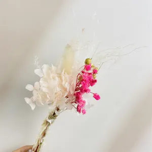 Closeup detail of dried preserved flower bouquet with small pink and white blooms for decor.