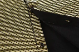 Close-up of mens gold shiny metallic long sleeve shirt fabric and button detail.