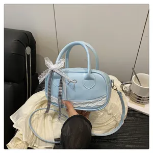 Vista dettagliata della borsa Boston azzurra con delicato pizzo bianco e nastri eleganti.