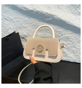 Vista dettagliata della borsa a mano con contrasto, logo M in metallo e patta testurizzata.