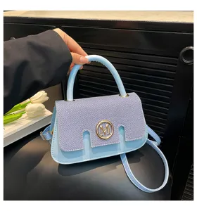 Vista di dettaglio della borsa a tracolla elegante in denim blu contrasto con logo metallo M.