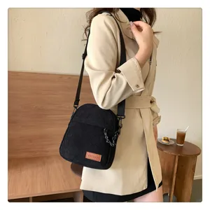 Black corduroy crossbody bag detail, casual daily shoulder bag with front pocket view.