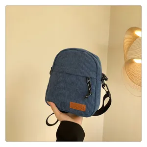 Blue corduroy crossbody bag detail, casual daily shoulder bag with zipper and strap.
