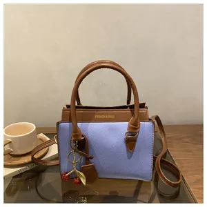 Chic color-block handbag with top handles and a cute cherry charm for women daily fashion style.