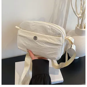 Casual minimalist nylon crossbody bag with multi-layer zipper and adjustable shoulder strap.