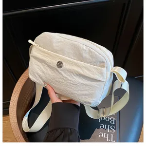 Detailed view of the casual white crossbody bag with multi-layer design and adjustable strap.