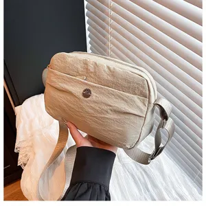 Detail shot of a casual nylon crossbody bag with multi-layer pockets and adjustable strap.