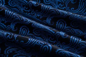 Close-up detail of luxury blue paisley jacquard fabric for men fashion suit jacket.