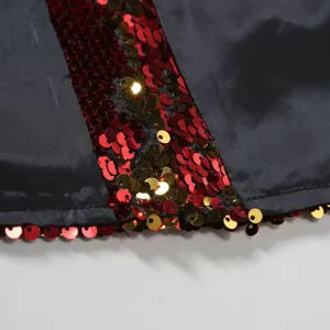 Gros plan de détail sur les sequins rouges et dorés de la veste queue-de-pie homme.