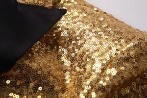 Vue detaillee des paillettes doree et du revers noir d'un blazer de costume pour homme.