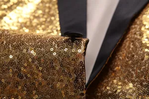 Vue de détail rapproché de blazer à sequins dorés avec tissu brillant et fin revers noir.