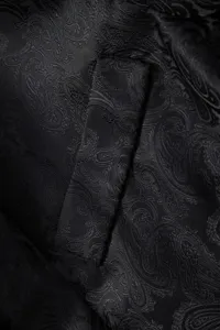 Close-up detail of men's black paisley jacquard suit jacket fabric showcasing texture.