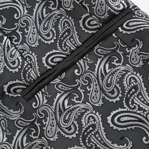 Men's suit jacket detail shot featuring elegant black and silver paisley jacquard fabric.