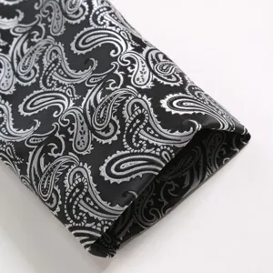 Detailed shot of men formal suit fabric with luxury black and silver paisley jacquard design.