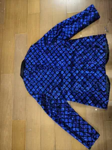 Detail view of men's blue sequin blazer with peak lapel and diamond pattern for stage wear.
