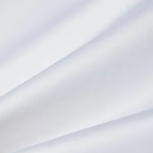 Λεπτομέρεια λευκού υφάσματος σε κοντινό πλάνο με λεία υφή και κομψή σατινέ γυαλάδα.