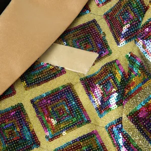 Men sparkling sequin blazer detail shot showing geometric square pattern and lapel fabric texture.