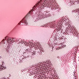 Detail view of men's pink sequin blazer fabric, featuring 3D square glitter pattern.